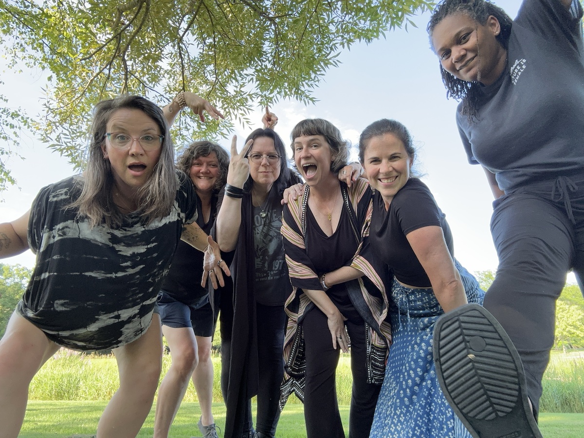 Photograph of six women, the (m)otherboard godmothers, in a band photo pose.